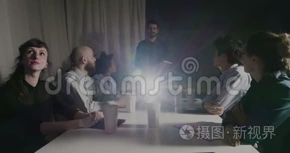 与同事在会议室观看演示文稿的商界人士