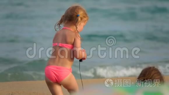 快乐的女孩在沙滩上拖着玩具视频