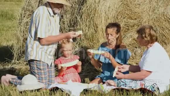 一家人在草地野餐时吃甜瓜视频