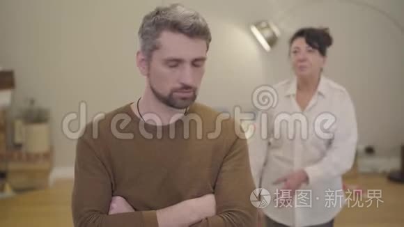 愤怒的白种人白发男子听着他的母亲责怪他的背景。 家庭关系问题