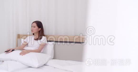 年轻女子在床上用远程闭路电视