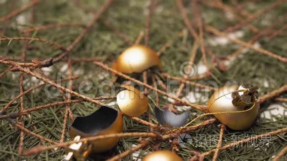 破碎的金色圣诞球躺在干燥的落针和圣诞树的树枝上。