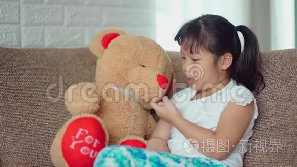 小女孩伤心地和大泰迪熊说话视频