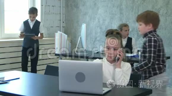 两个小孩子在现代办公室讨论和工作笔记本电脑