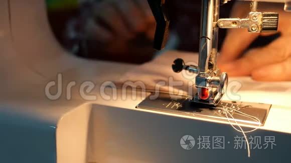裁剪工艺-女性手使用缝纫机与内置灯的光，这将是纺织服装
