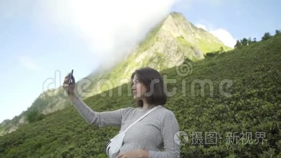 女人在高加索山脉的中心地带自拍。 自由和冒险的概念..