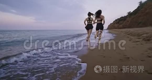 健康的生活方式理念：两位年轻的女士早晨在海滩上奔跑，带着令人惊叹的风景