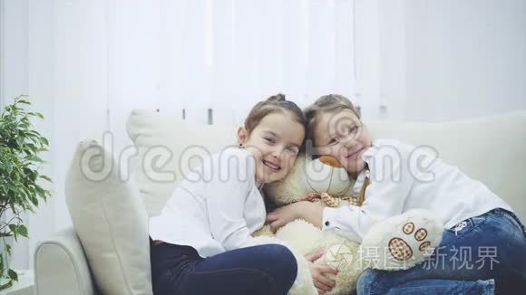 两个可爱的快乐女孩在玩泰迪熊，拥抱他们毛绒朋友，微笑，看起来可爱..