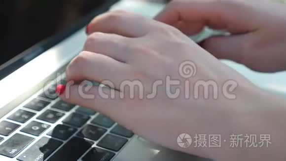 关闭女性手在笔记本电脑键盘上键入一些文本。 商业女性在户外使用笔记本。 创意女性