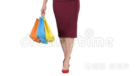 让`去购物吧！！ 漂亮的女人腿，带着购物袋走在白色的背景上。