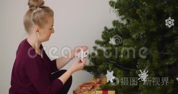 女人用装饰品和灯光装饰圣诞树