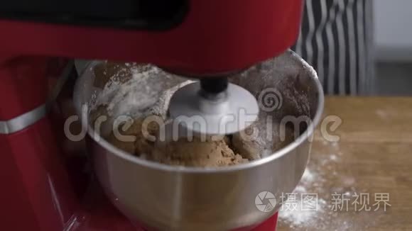厨师用红色的厨房搅拌机做面团。 厨师添加面粉以获得正确的稠度