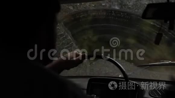 从一辆旅行车穿过挡风玻璃观看秋天的森林道路