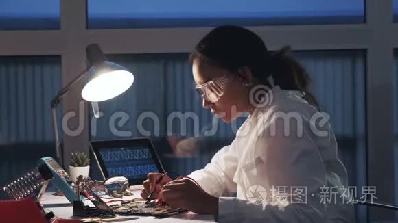 女电子工程师，在实验室中使用万用表和其他电子设备