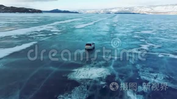 冬天，汽车在贝加尔湖的蓝色冰层上行驶。 从四翼飞机后面的跟踪视图