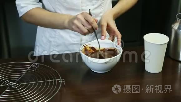 厨师统一配置的甜点在深白碗中配制液体巧克力釉