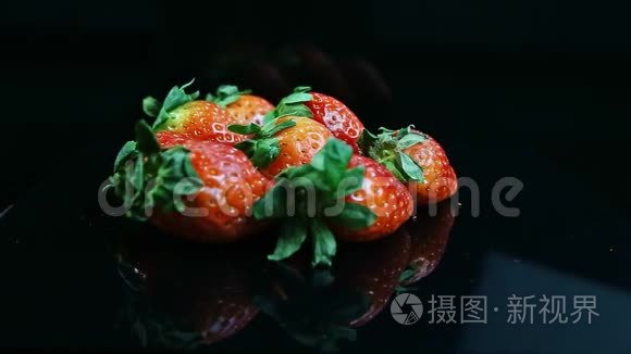 一组新鲜多汁的红草莓呈黑色视频