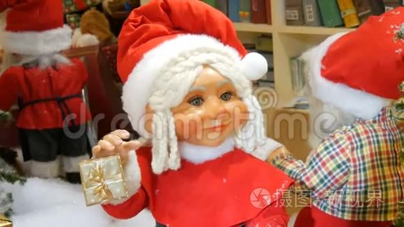 在购物中心的圣诞展览中移动女圣诞老人玩偶。 圣诞假日装饰