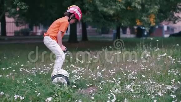 少年站在草地上的陀螺仪上视频