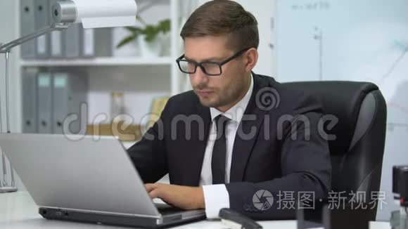 穿西装的男人在笔记本电脑上打字，摘下眼镜时感到眼睛紧张