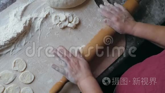 在家厨房里，高级女性的特写手在擀面包饺子