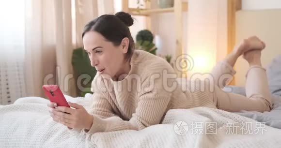 女人在床上放松时用手机唱歌