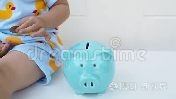 一个孩子正在把硬币放在蓝色的储蓄罐里，为未来的概念储蓄。 儿童教育。