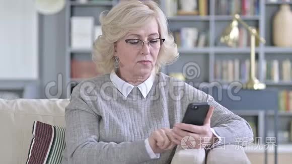 悲伤的老女人面对智能手机的损失