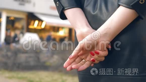 双手特写。 女人站在街上摘下结婚戒指