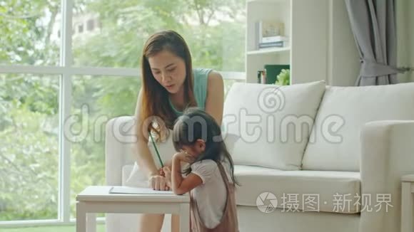 年轻的母亲教可爱的女儿画画视频
