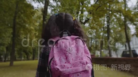 在公园散步的女学生的后景。 回到学校的概念。 慢动作镜头。