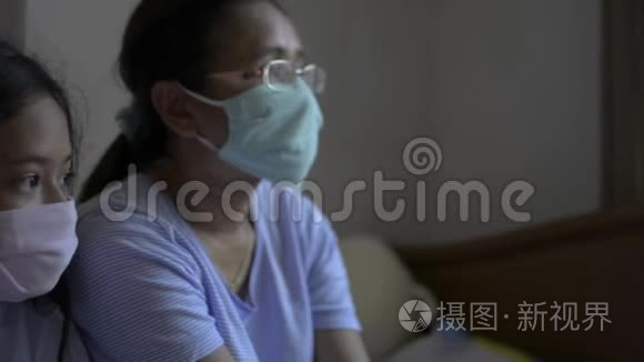 母亲和女儿戴着防护面罩，以保护自己免受电晕病毒的影响，并呆在家里。