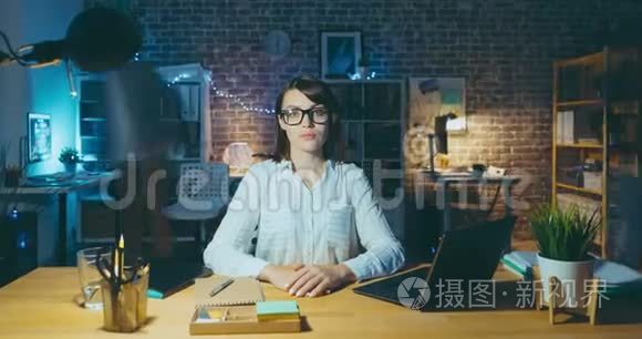 在办公室办公桌前工作的漂亮女人的变焦延时画像