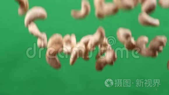 腰果在绿色背景上上下飞行。 用腰果烹饪健康食品