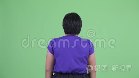 年轻超重的亚洲女性触摸某物的后视图