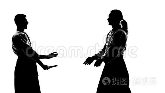 两名男性在基科吉或和服中的黑色细枝末节，用坦托表现出合气道。 孤立无援，白人。 慢动作。 快关门。