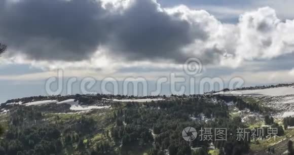 山顶后面云景的时间流逝。 雪，岩石，悬崖和深蓝色的天空。 高空。