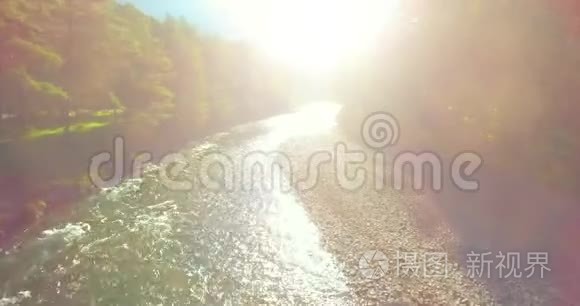 在阳光明媚的夏季早晨，低空飞行在带岩石的新鲜快山河上。