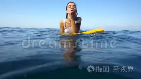 美丽的女孩躺在海面上的木板上视频