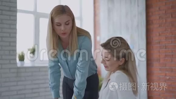 在办公室里，一个微笑的金发美女和她的助理员工聊天。 4k