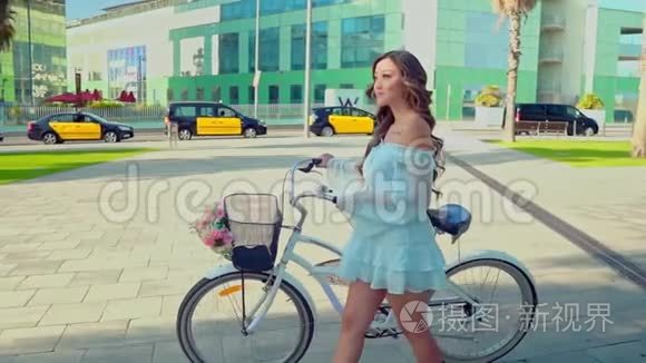 穿着蓝色衣服的亚洲模特骑着白色自行车在绿色公园里