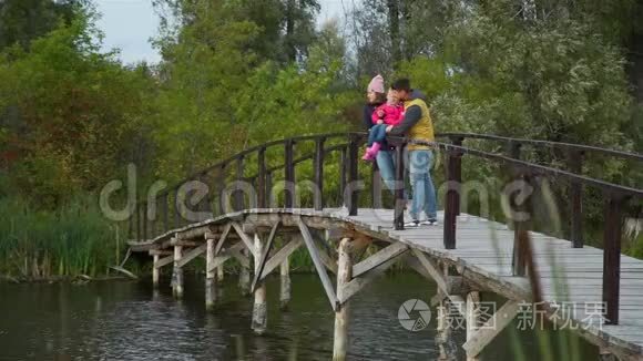 一家人站在湖边的木桥上视频