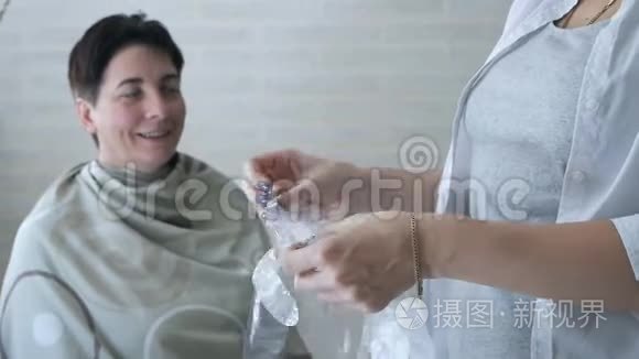 女孩戴上玻璃纸手套。 染发剂