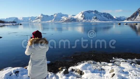 女孩在阳光明媚的冬季峡湾拍照视频