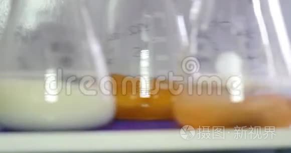 三个厄伦迈尔烧瓶，其中一些食品样品正在旋转-食品质量检查