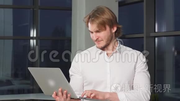 现代男性自由职业者手拿笔记本电脑的画像