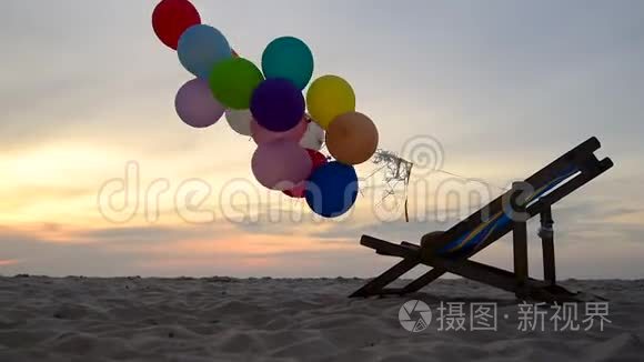 夏天日落时在海滩上的剪影气球。 五颜六色的气球放在座位上。 户外旅行生活方式