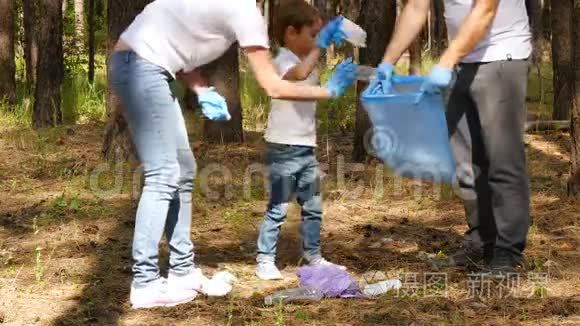 家庭积极分子在树林里收集垃圾。 孩子把垃圾放在一个可生物降解的袋子里。 关怀的概念