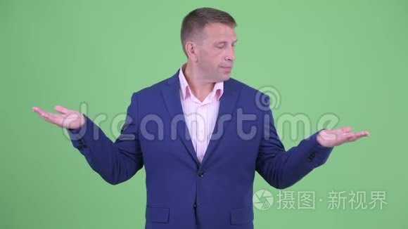 成熟的有男子气概的商人在比较视频