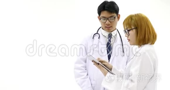 亚洲女医生用药片和男医生谈论病人病情。